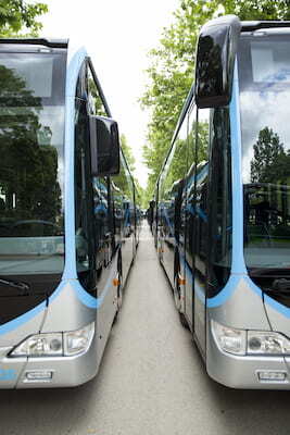 two parked charter buses with blue and silver trim