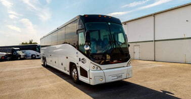 a plain white charter bus from MGM Tour